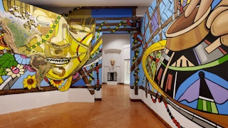 A colorful display in the foreground frames a bust in the room beyond